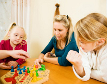 Des enfants et une adulte jouant à un jeu de société